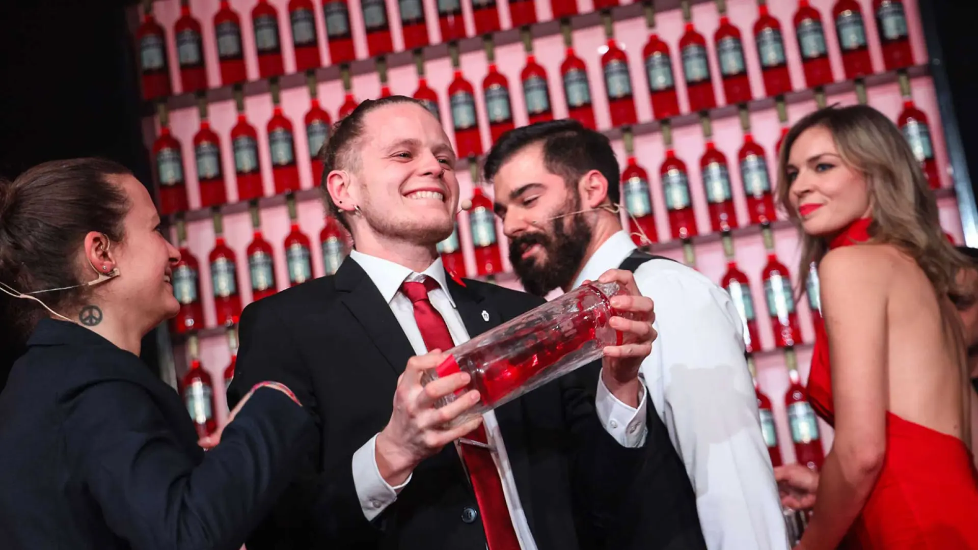 Group of Campari brand ambassadors celebrating with cocktails, surrounded by iconic Campari bottles, highlighting the brand’s vibrant spirit and commitment to mixology and social experiences