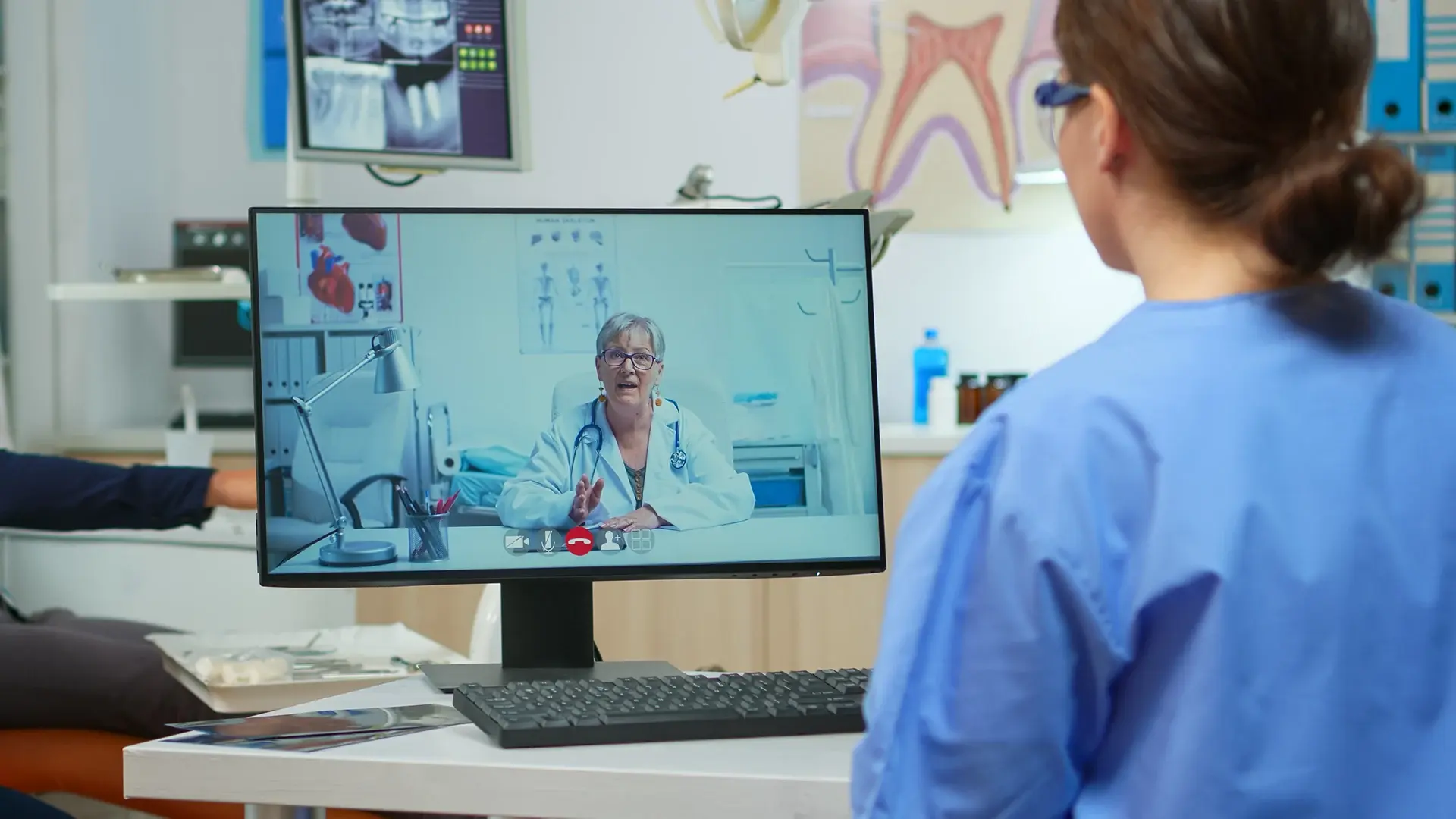Healthcare professional reviewing clinical video on desktop monitor during multi-site consultation