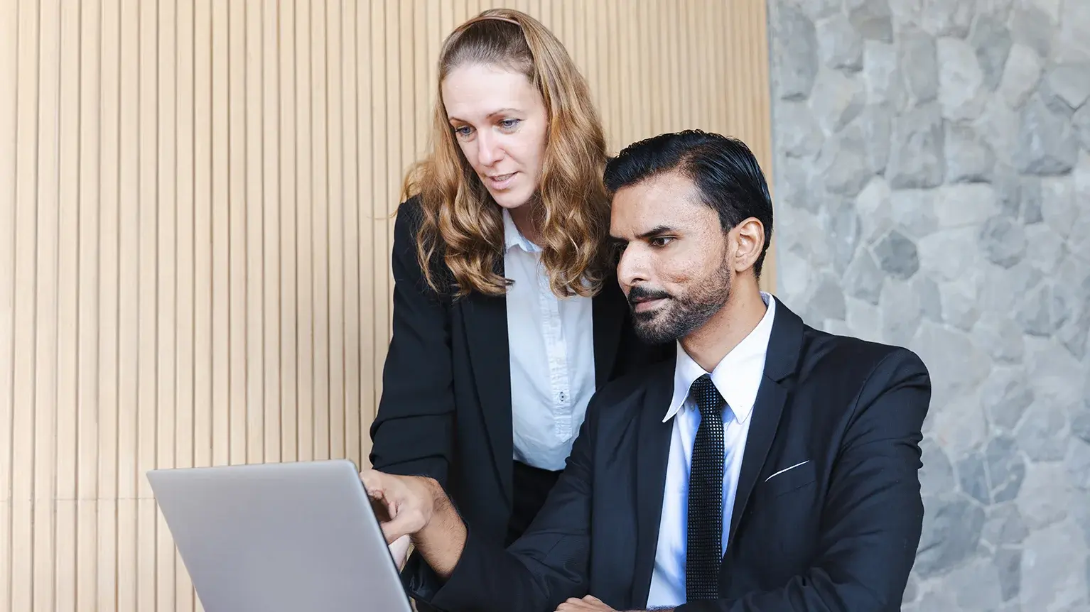 Two professionals discuss together in a polished office setting, engaged in discussion, reflecting Davis Polk’s collaborative and professional environment in the legal field