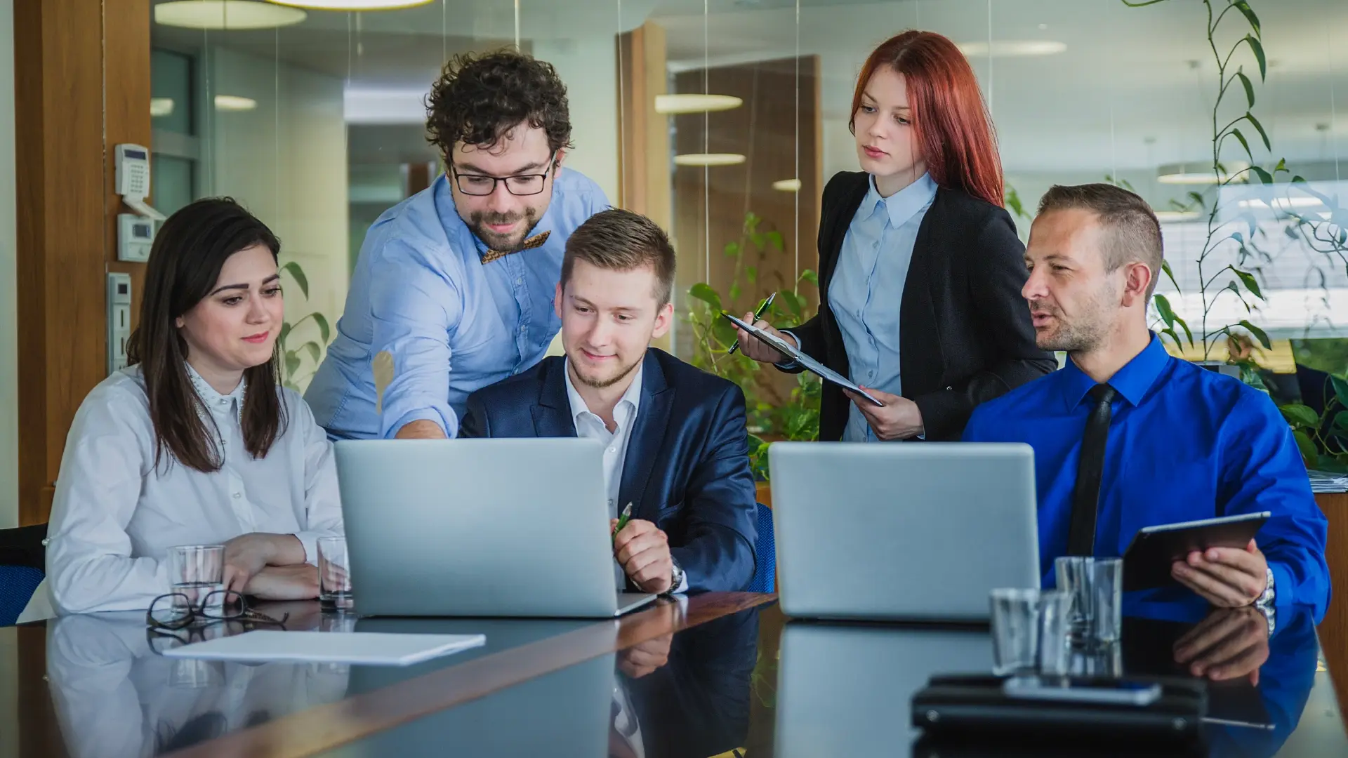 A collaborative team meeting with business professionals working together on laptops and tablets, reflecting the Entrepreneurs Foundation’s commitment to fostering entrepreneurial growth, innovation, and mentorship