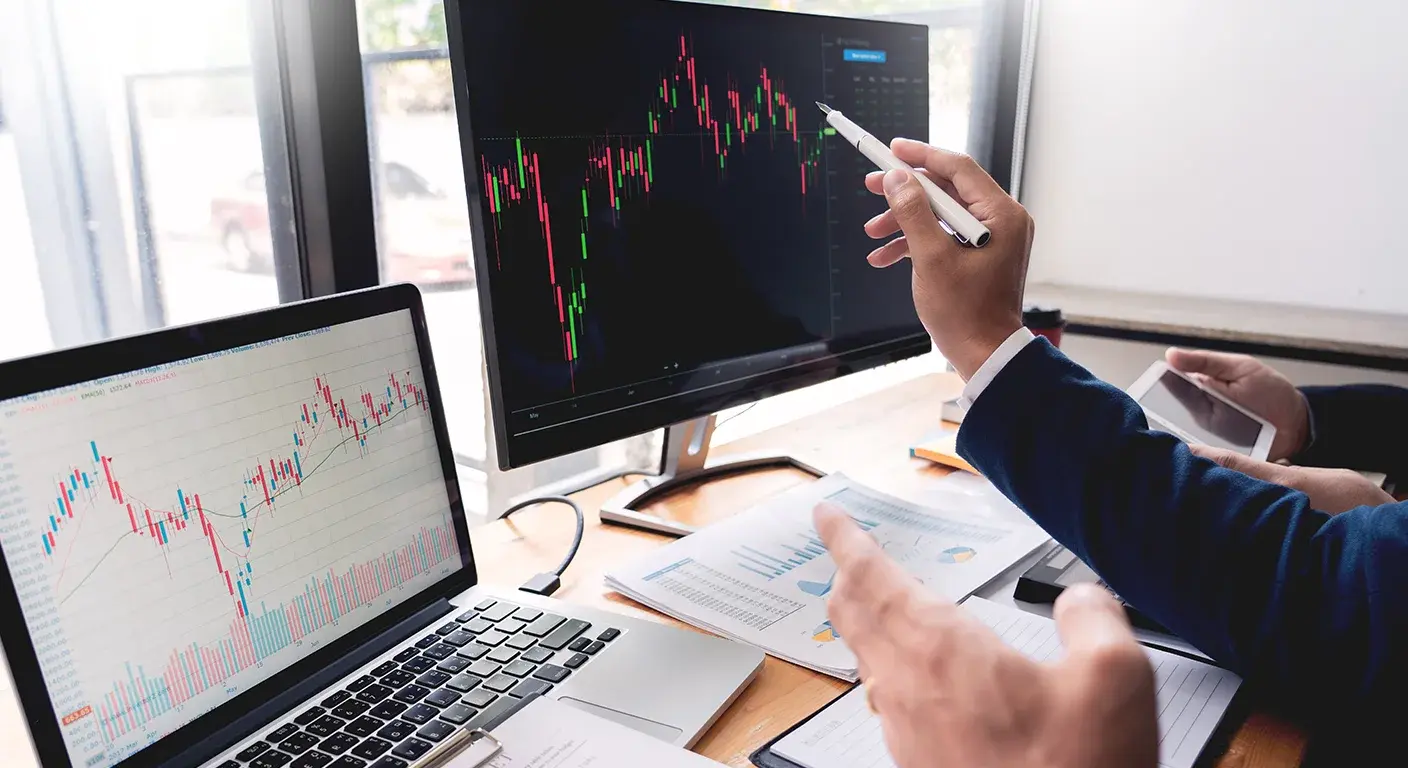 Two business professionals reviewing financial reports and charts on paper and a tablet, reflecting strategic analysis and data-driven decision-making, indicative of Haidar Capital Management's financial advisory and investment service