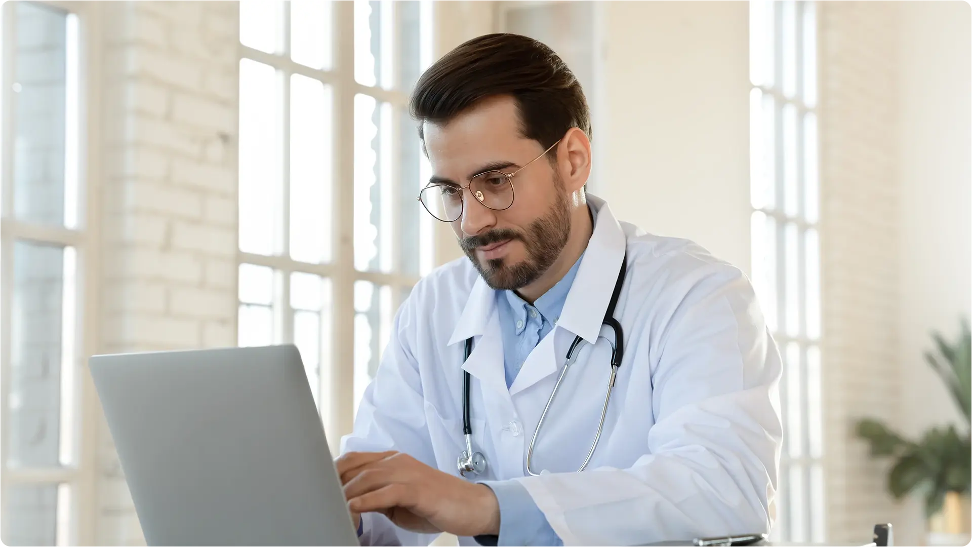 A doctor and two healthcare professionals review a chart together in a hospital corridor, representing VIDIZMO’s support for secure video solutions in healthcare for training, collaboration, and patient care