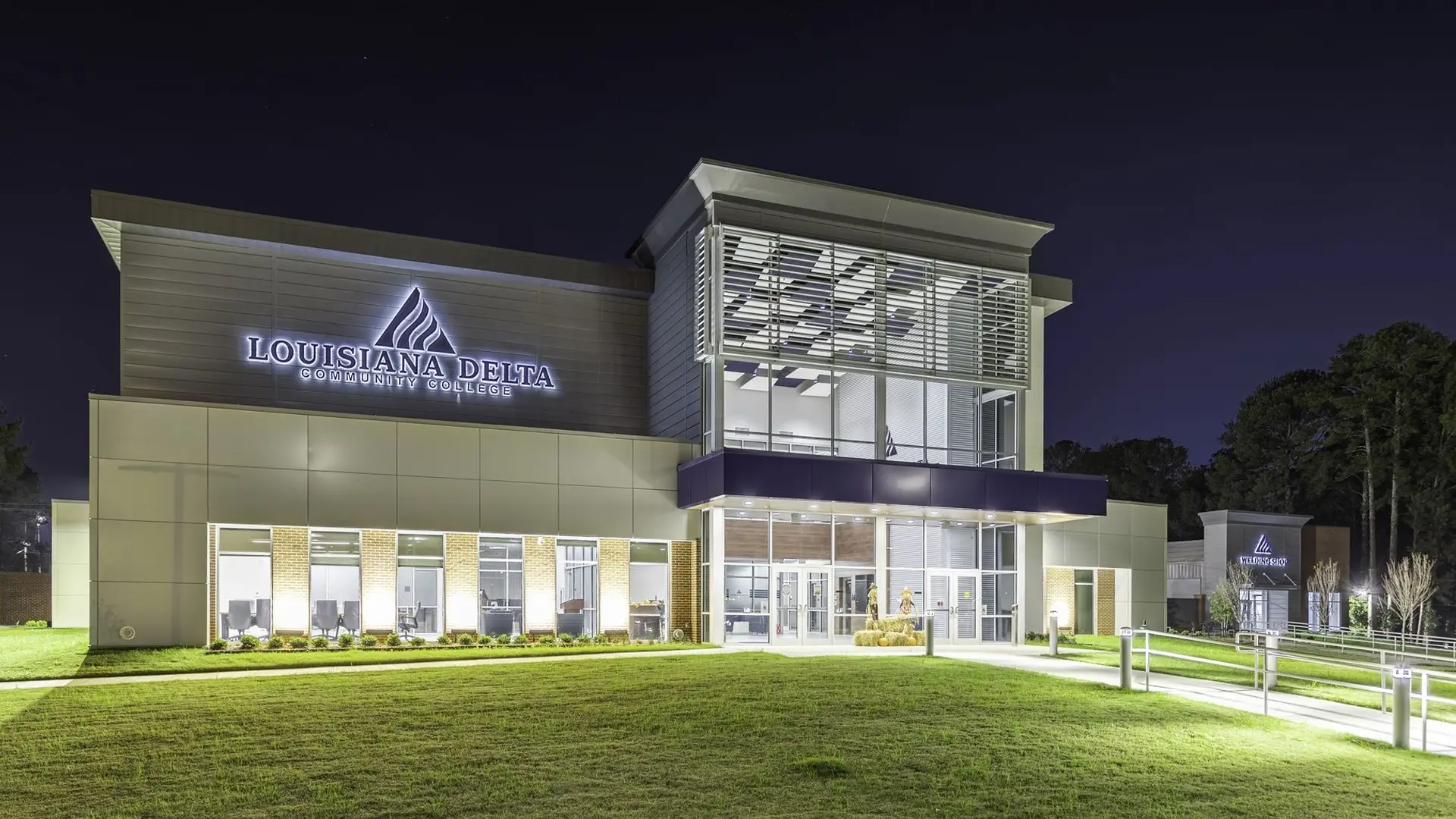 Exterior of Louisiana Delta Community College building illuminated at night, showcasing modern architecture and a welcoming campus environment