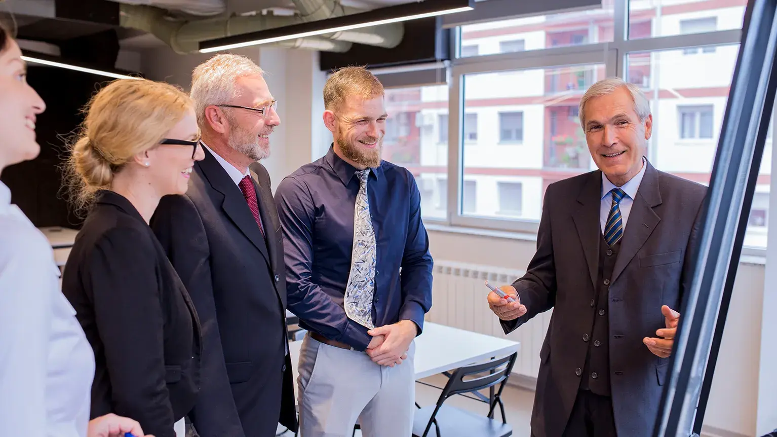 Group of professionals standing on stage at a Meridian International Center event, with the Meridian logo displayed on a large screen in the background, symbolizing global leadership and diplomatic exchange initiatives