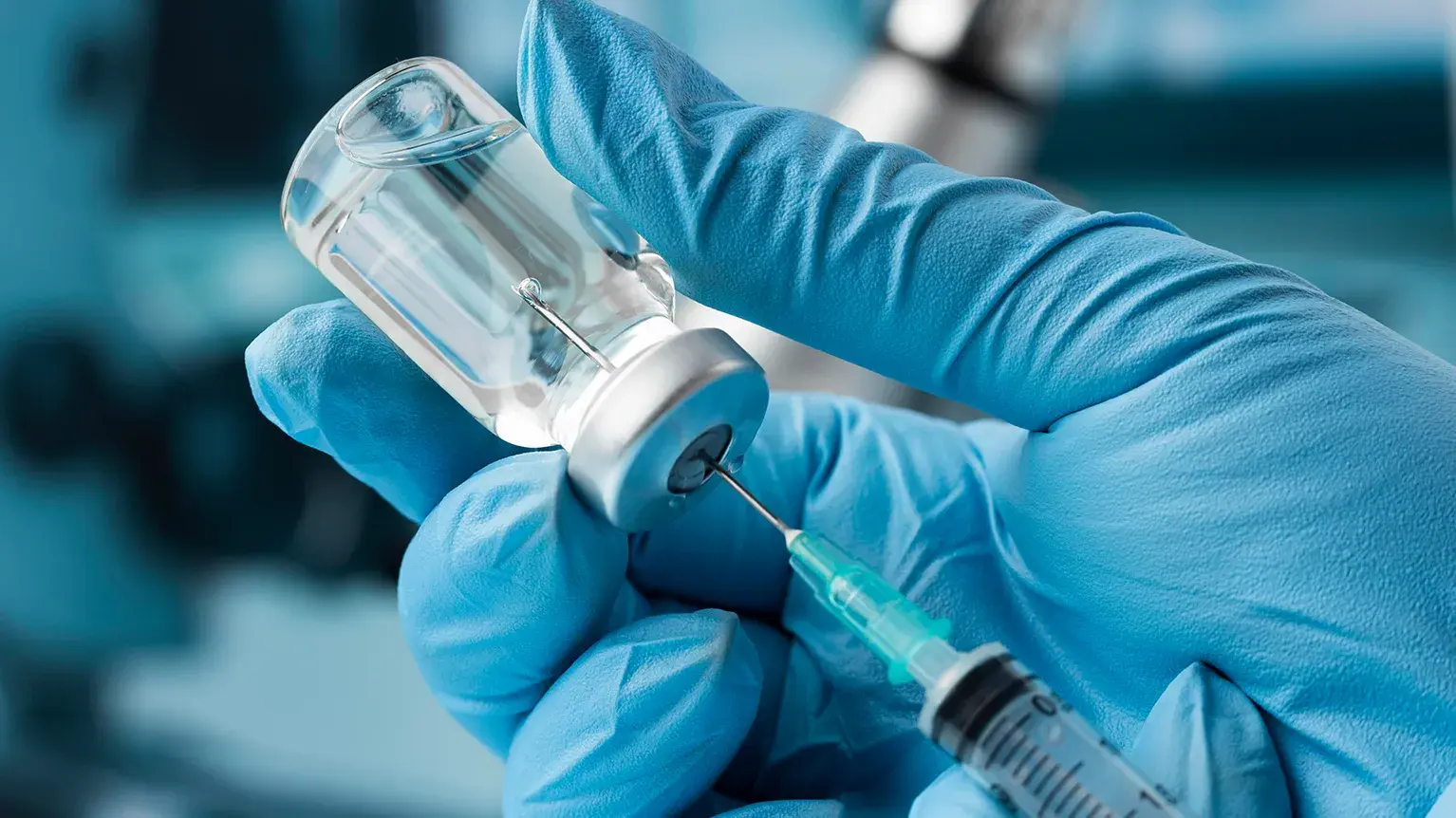 Healthcare professional preparing an injection in a pharmacy setting, representing the pharmaceutical packaging and drug development services provided by PCI Pharma Services