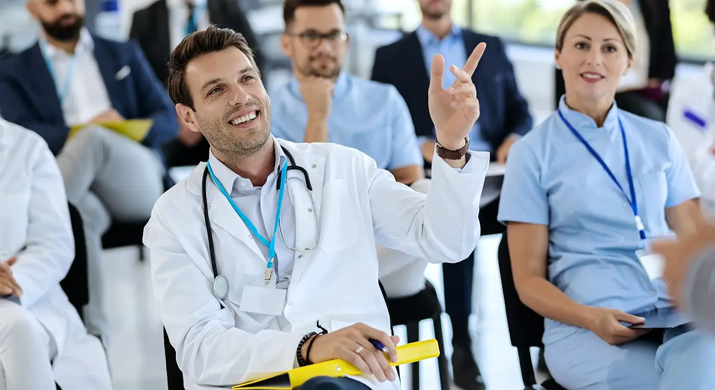 A group of smiling medical students in white coats at UMass Chan Medical School, symbolizing their dedication to healthcare and medical education