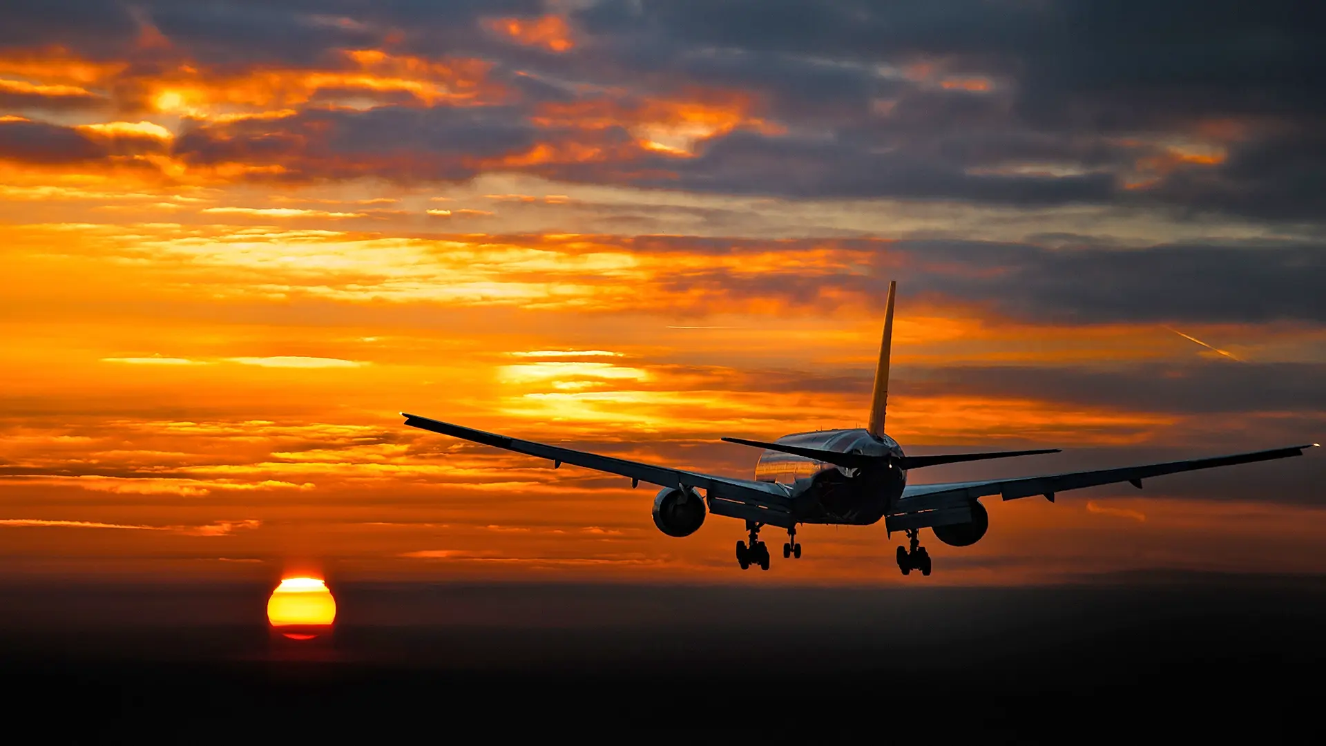 A commercial airplane approaches landing against a dramatic sunset, symbolizing aerospace advancements. This image relates to VIDIZMO’s role in aerospace, possibly supporting video-based solutions for training, safety, or operational improvements in aviation