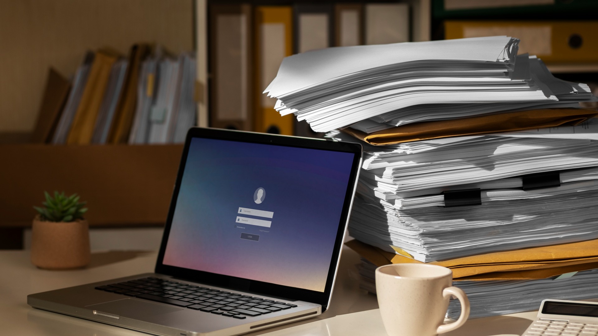 a laptop with an enterprise video platform running next to some physical files